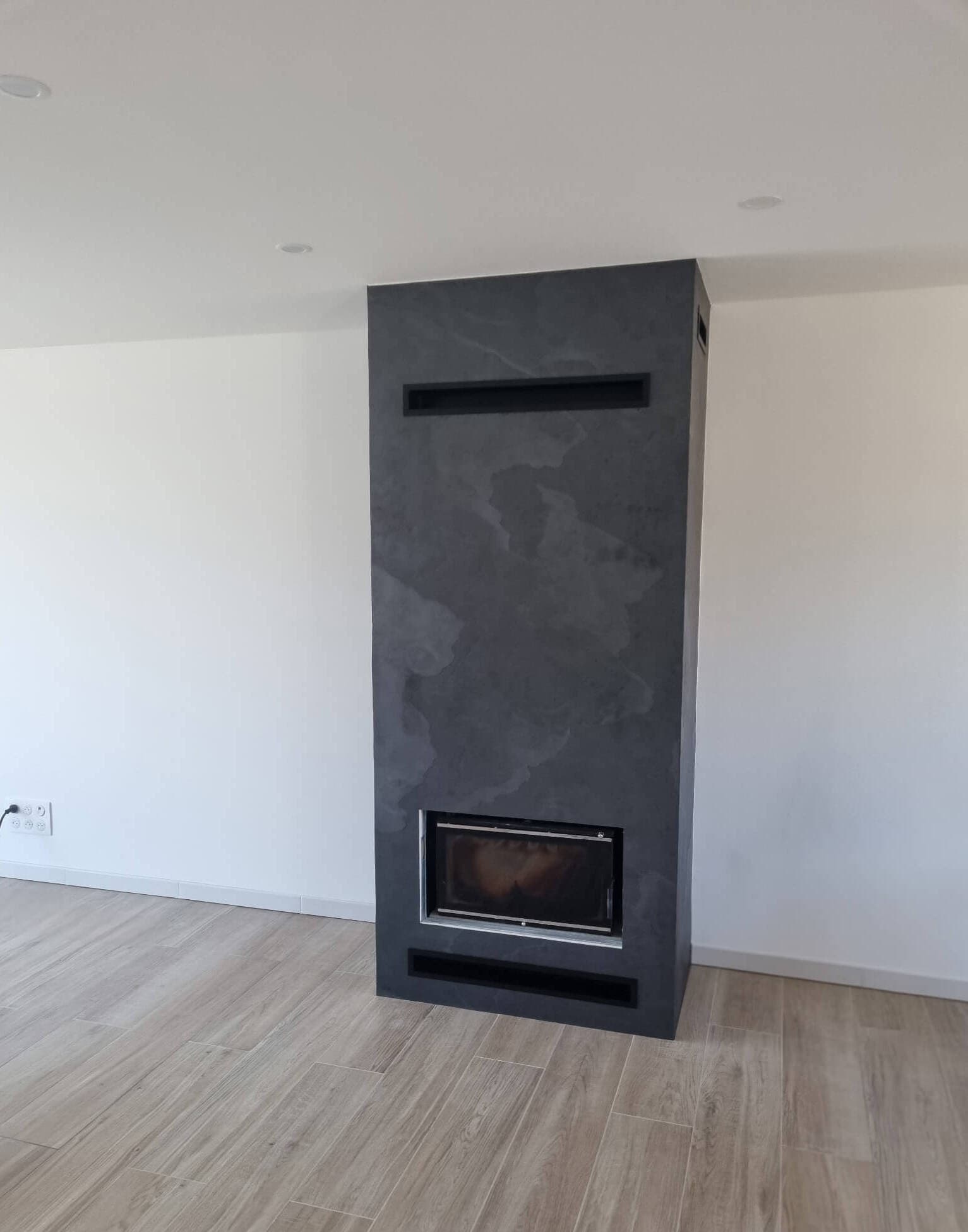 Cheminée habillée d'enduit béton et niches intégrées