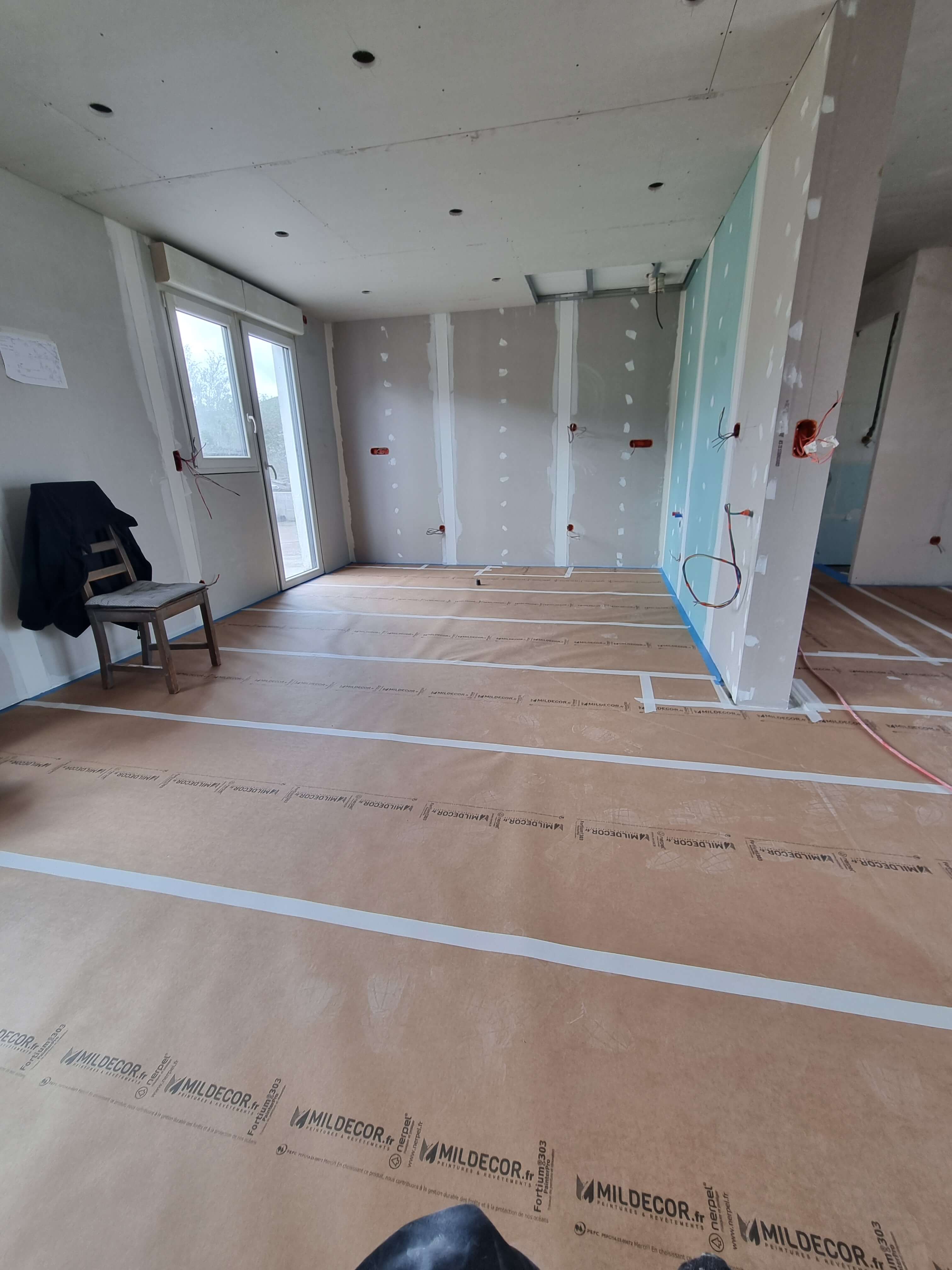 Cloisons montées et bandes en cours, sol protégé pendant toute la durée du chantier